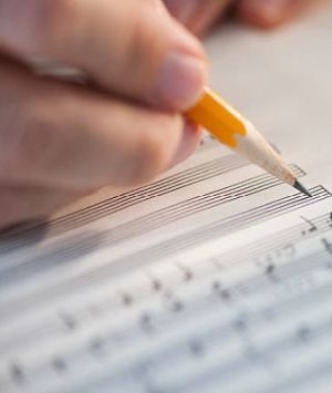 A music composer writing notes on a music sheet